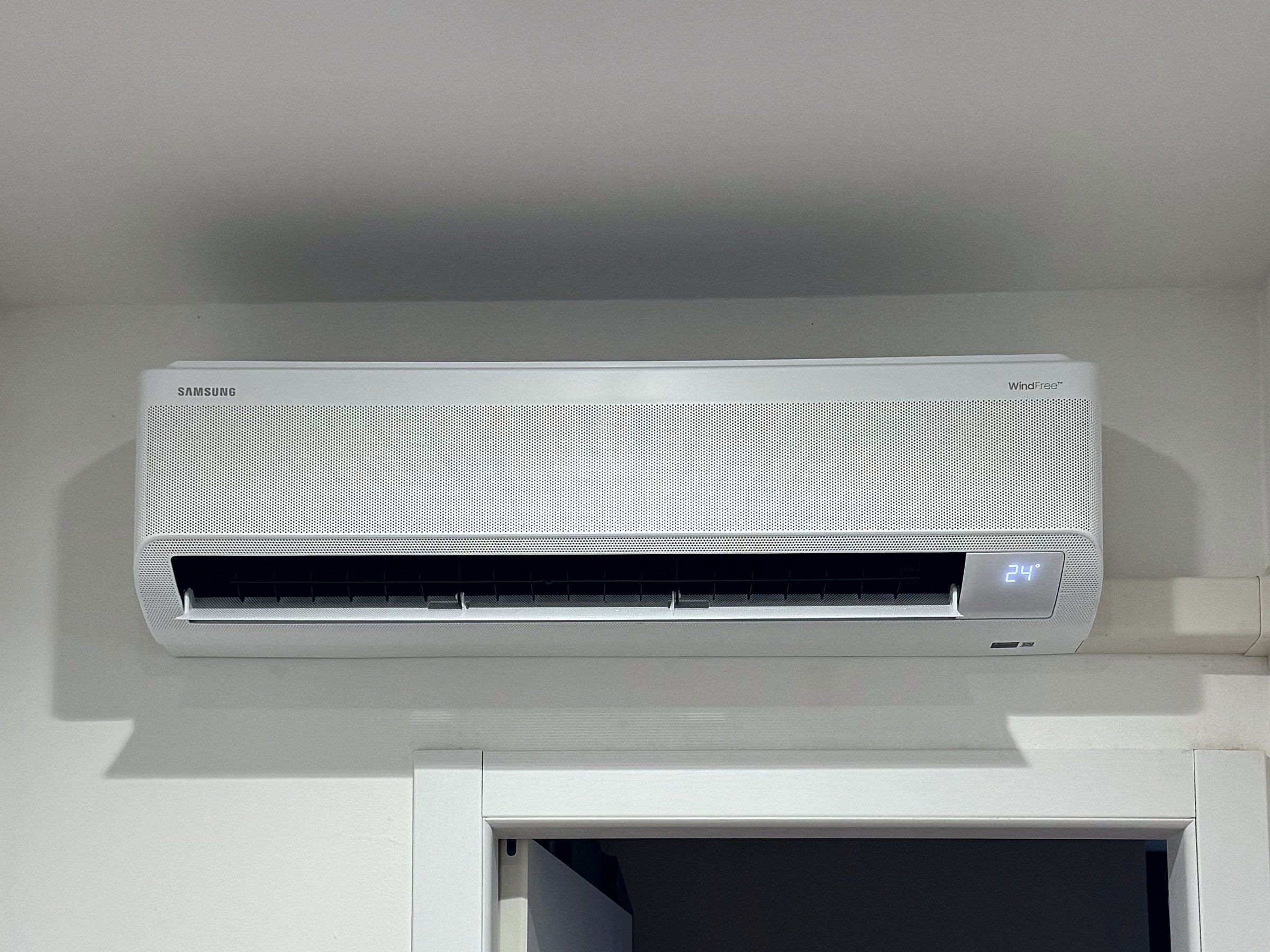 Climatizzatore a parete appena montato sopra una porta, con il display acceso